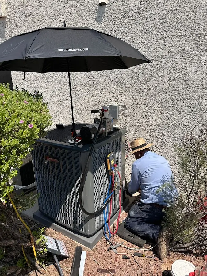 HVAC technician performing outdoor AC maintenance in Earl