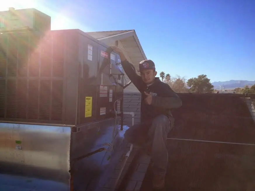 HVAC technician performing Boiler Repair on a rooftop unit in Earl